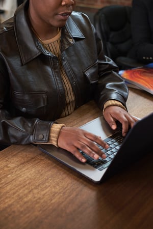 A trans person working on a laptop in an office(1)